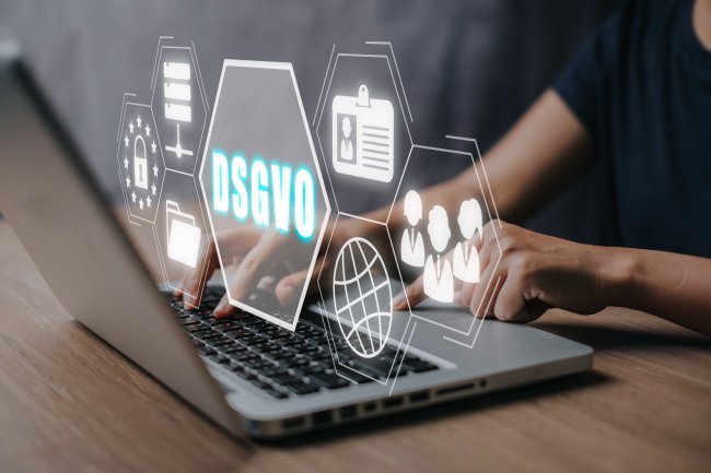 DSGVO Datenschutz-Grundverordnung Konzept, Person arbeitet am Laptop mit DSGVO-Symbol auf virtuellem Bildschirm.