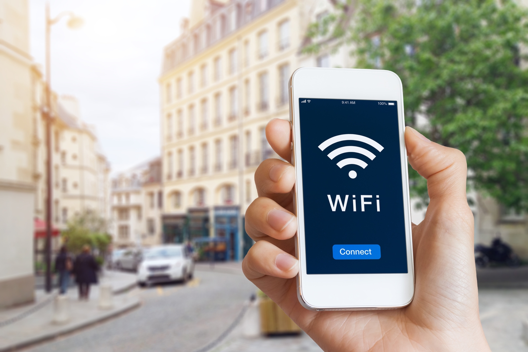 Connection to public WiFi hotspot in the city street to access internet on smartphone, concept about wireless technology and travel, close-up of hand