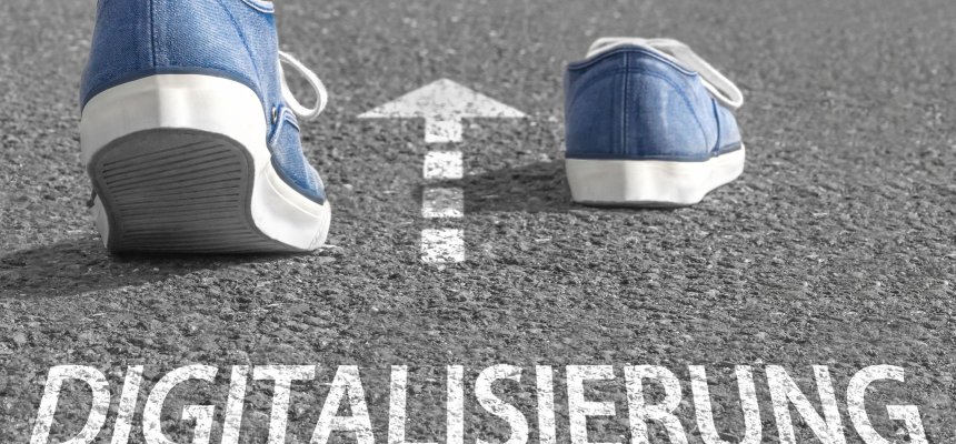 Shuhe laufen über eine Straße, darunter steht Digitalisierung