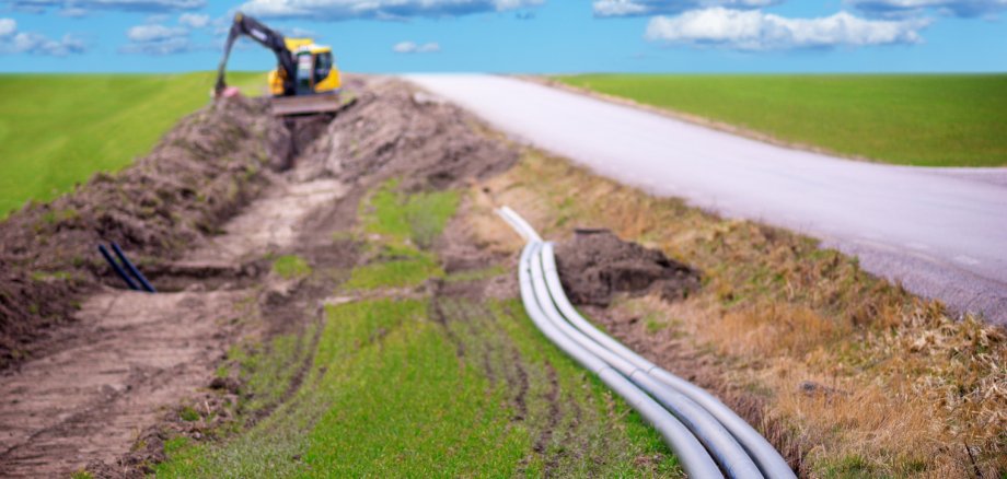 Erdbagger zum Ausheben von Kabeln für Breitbandverbindungen in ländlichen Gebieten