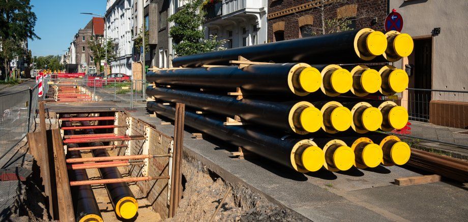 Ein Stapel neuer Rohre für Fernwärme an einer Baustelle in Düsseldorf, Deutschland