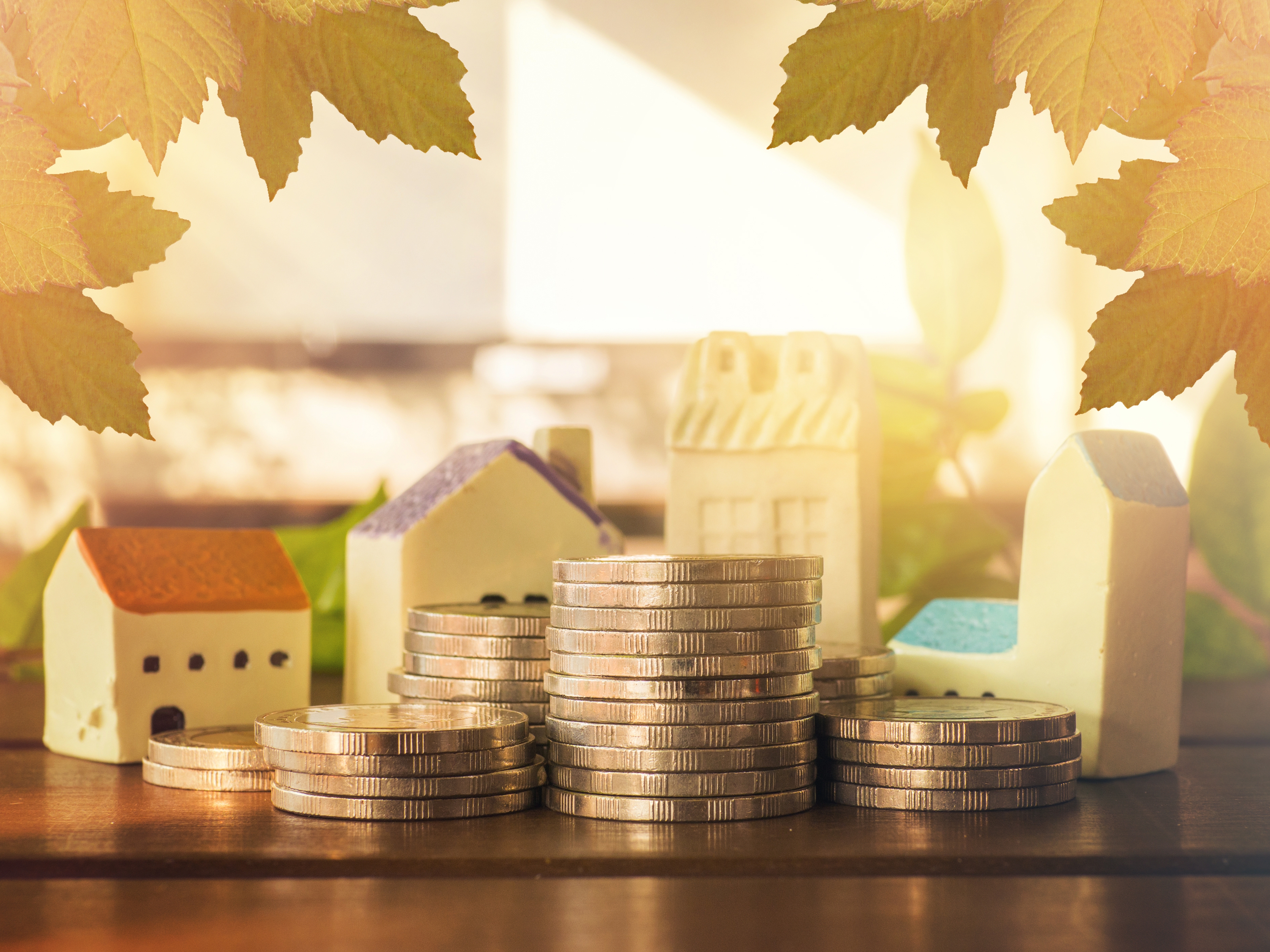 Collage Geld und Häuser Bildcollage aus Geldmünzen und Modellhäusern