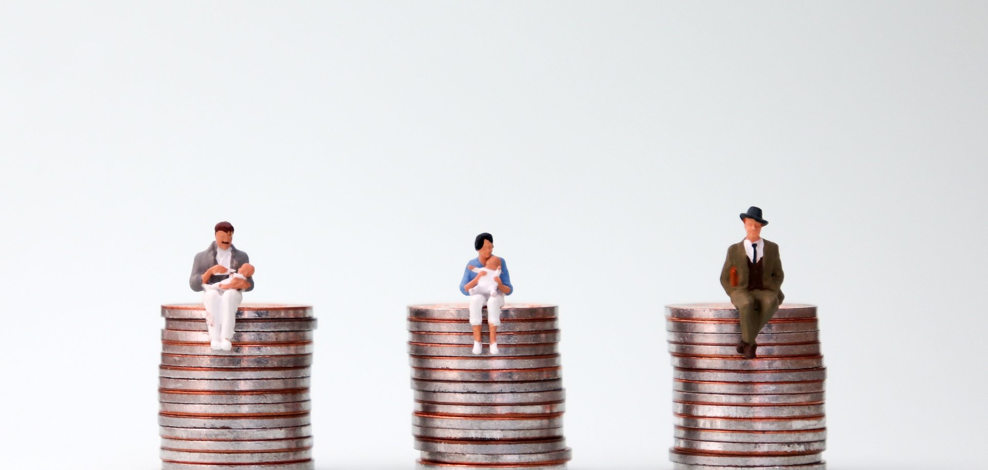 An equal pay concept. Miniature people sitting in the same height pile of coins. Geldmünzen