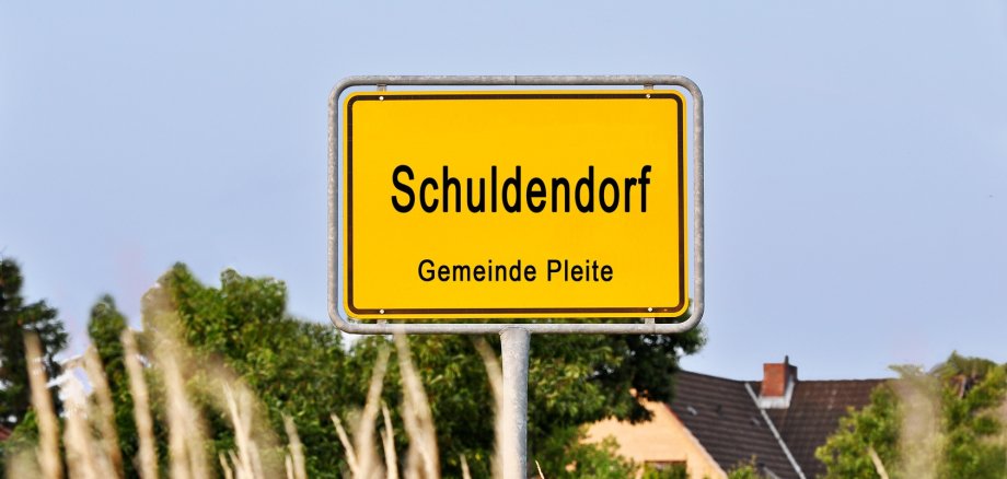 Schild mit der Aufschrifft ,,Schuldendorf"