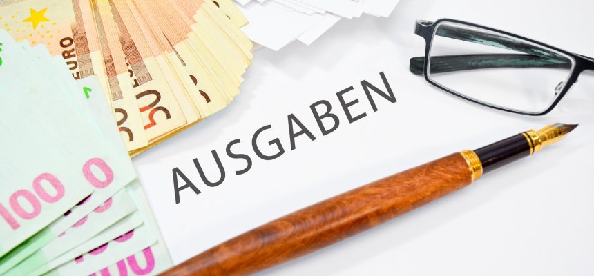 Geld und Stift dazwischen Steht ausgaben