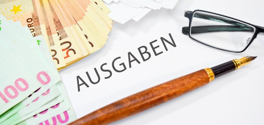 Geld und Stift dazwischen Steht ausgaben