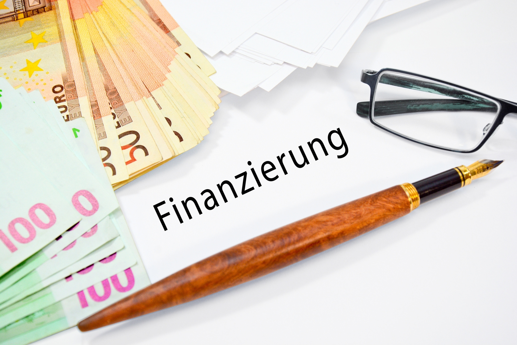 Geld, Stift und Schild mit Finanzierung