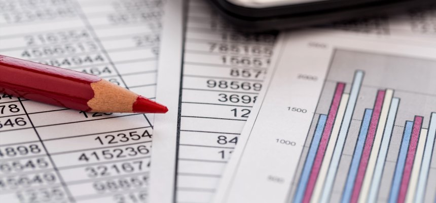 Taschenrechner und Statistk Ein Taschenrechner liegt auf den Zahlen einer Bilanz uns Statistik. Symbolphoto für Umsatz, Gewinn und Kosten.