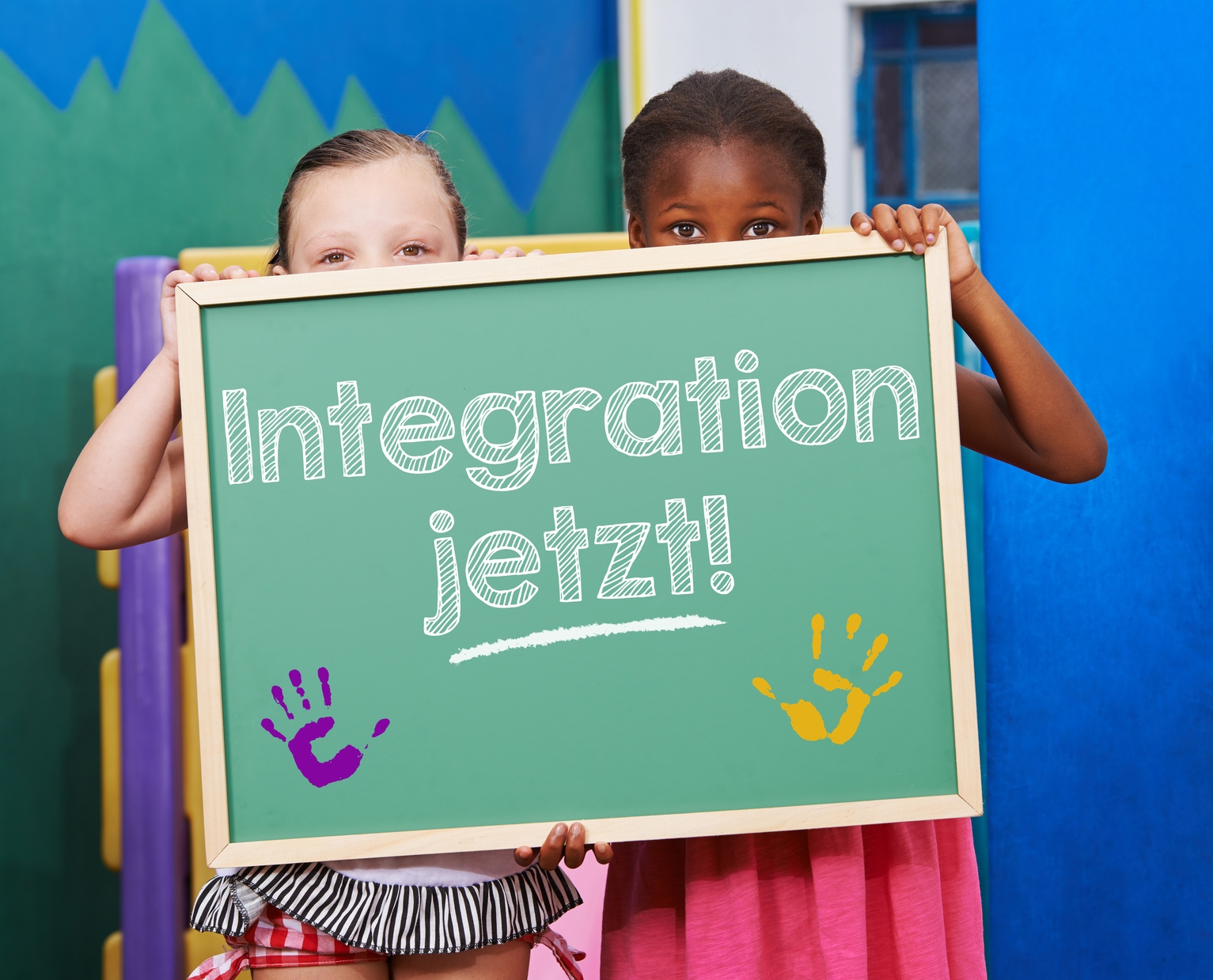 Zwei Kinder halten Tafel mit dem Spruch "Integration jetzt!" im Kindergarten