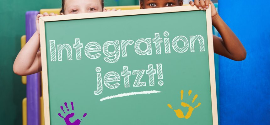 Zwei Kinder halten Tafel mit dem Spruch "Integration jetzt!" im Kindergarten