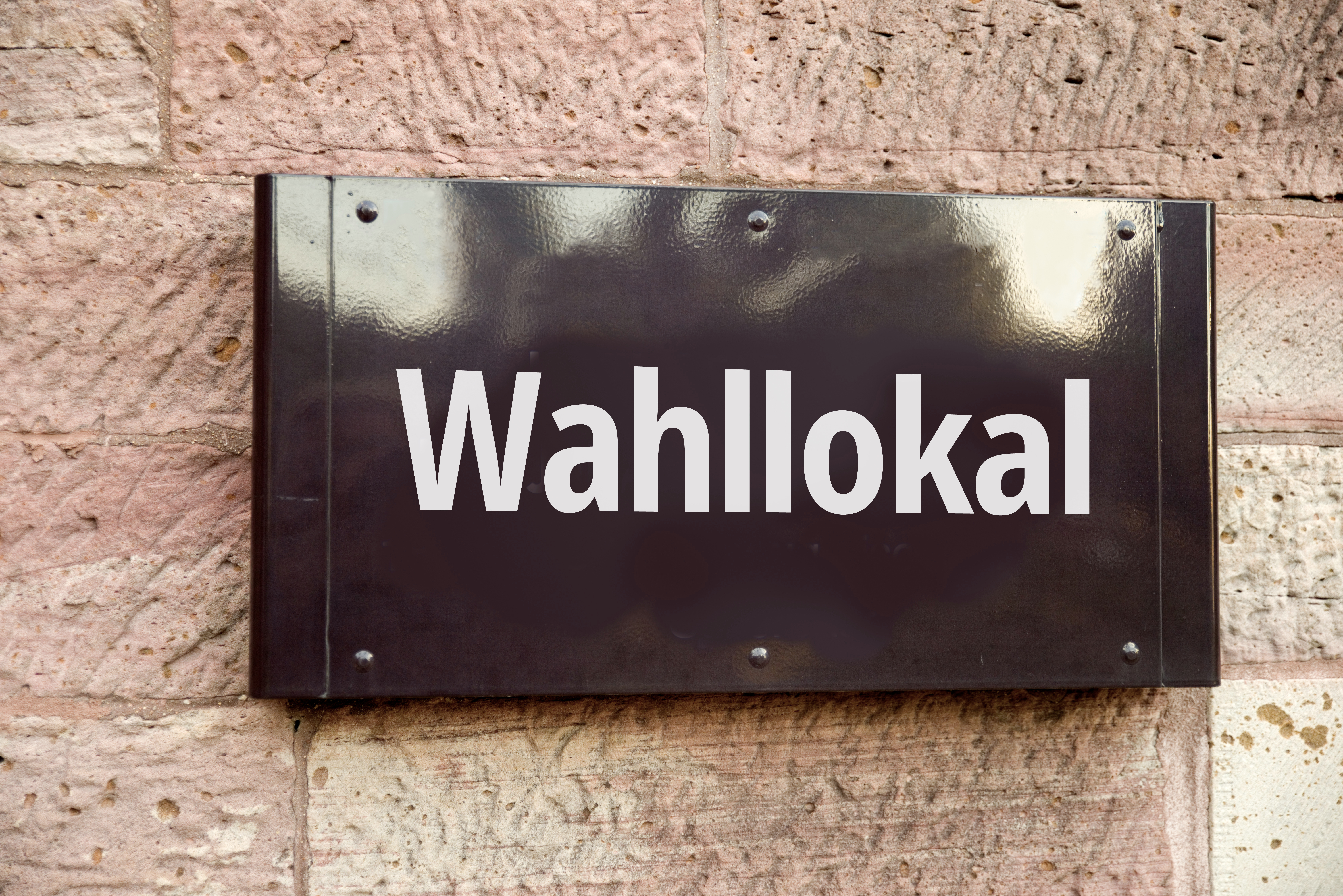 Schild "Wahllokal" an einer Hauswand