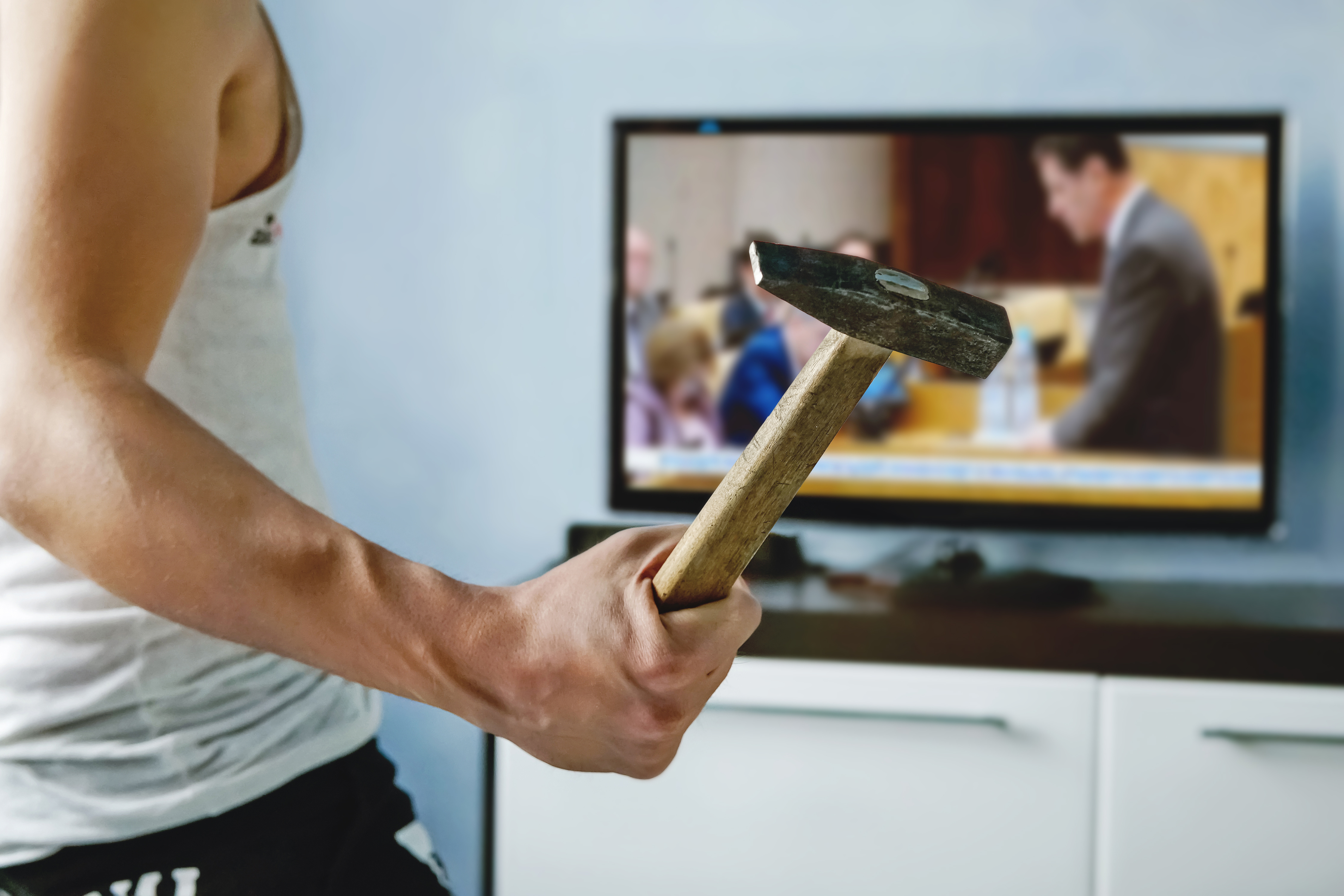 Psychopath mit Hammer Ein Psychopath will mit einem Hammer ein TV Gerät zerstören, auf dem ein Politiker zu sehen ist.