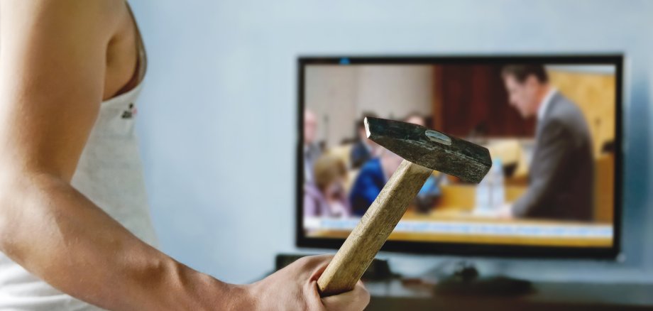 Ein Psychopath will mit einem Hammer ein TV Gerät zerstören, auf dem ein Politiker zu sehen ist. 
