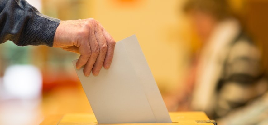 Stimmzettel wird in Wahl Urne getan.