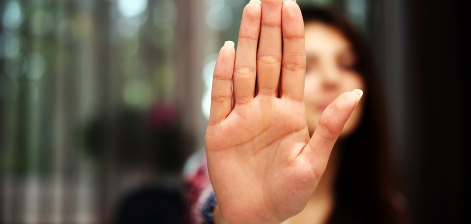 Frau zeigt mit Hand an zu Stoppen
