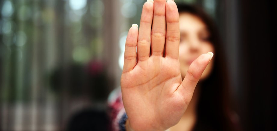 Frau zeigt mit Hand an zu stoppen