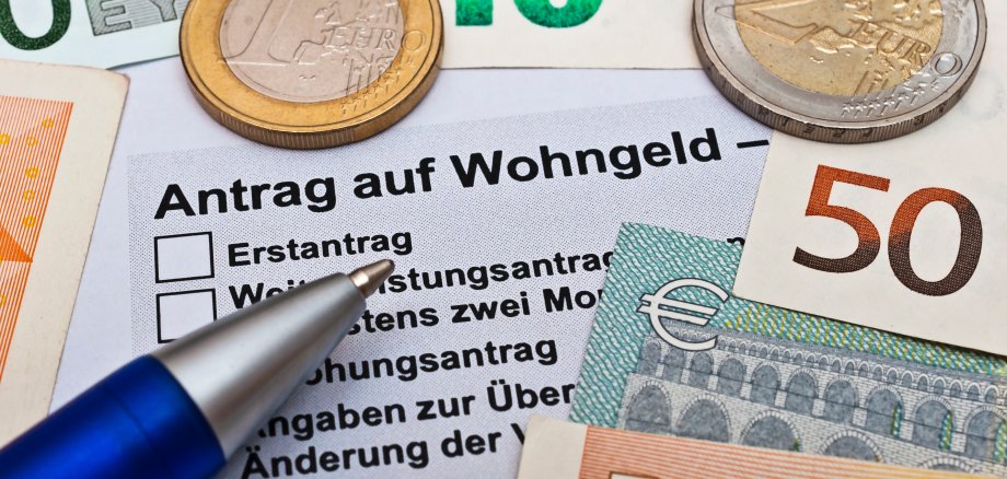 Wohngeld beantragen Wohngeldantrag mit Geldscheinen und Stift