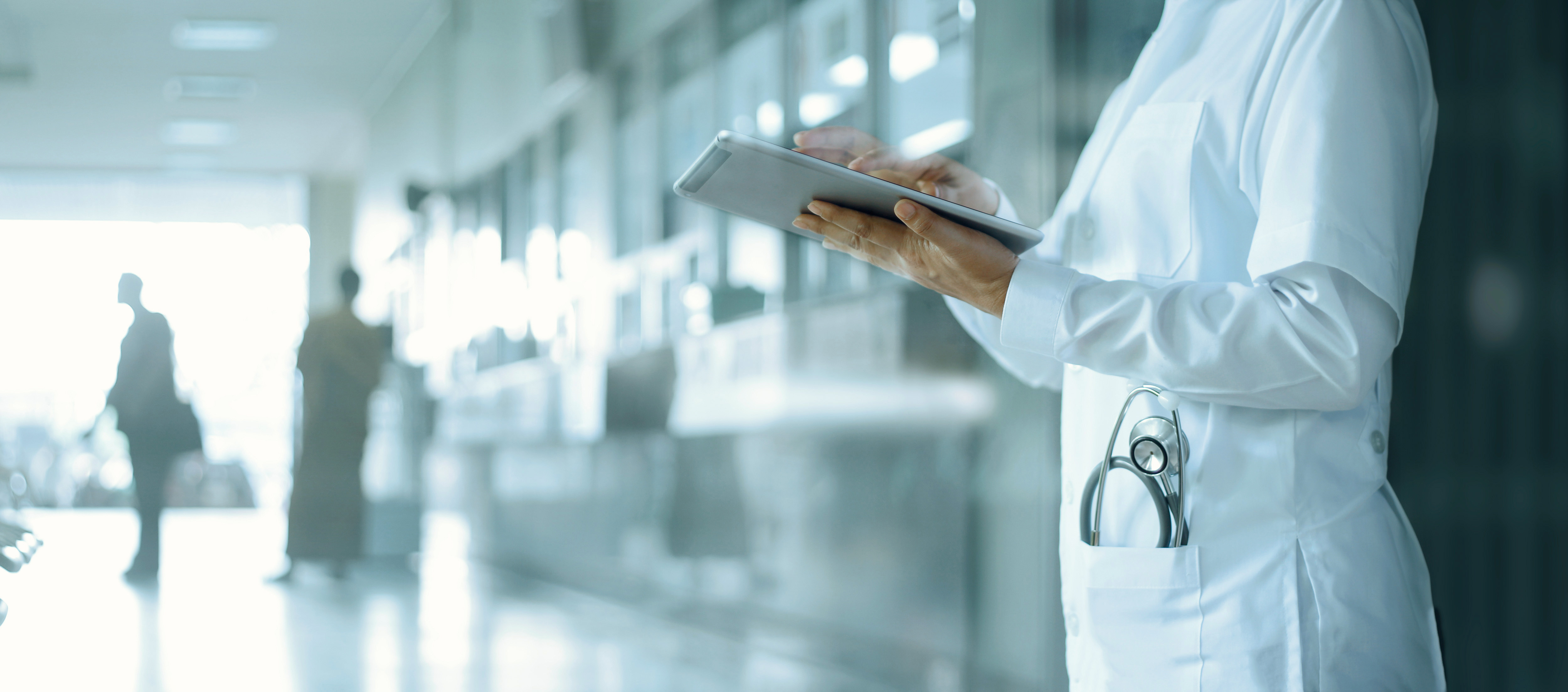 Doktor arbeitet an einem Tablet in einem Krankenhaus.