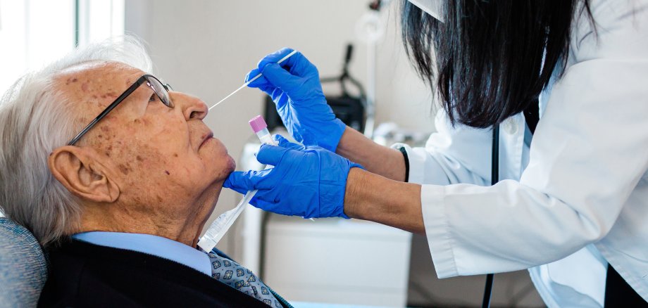 Krankenschwester, die einen Coronavirus PCR Test an einem älteren Mann in seiner Wohnung durchführt. Krankenschwester, die einen Coronavirus PCR Test an einem älteren Mann in seiner Wohnung durchführt.