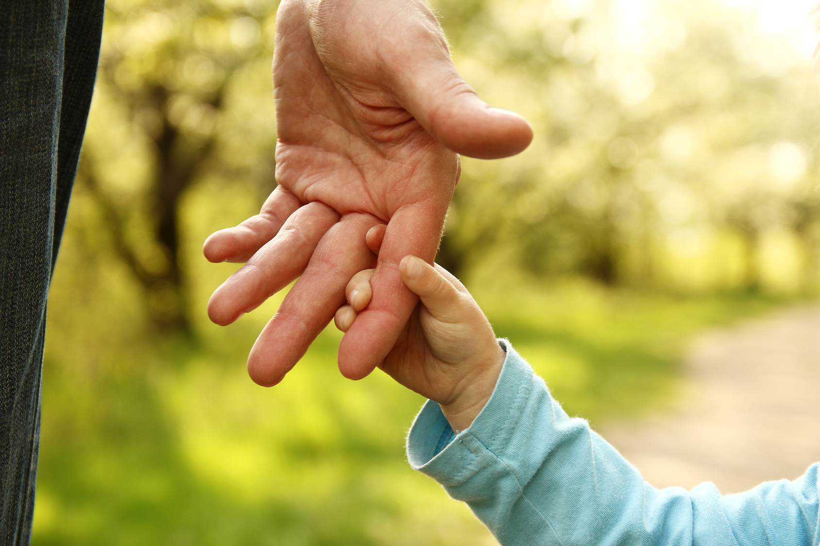 Elternteil hält Kinderhand