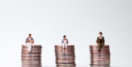 An equal pay concept. Miniature people sitting in the same height pile of coins. menschen auf Geld