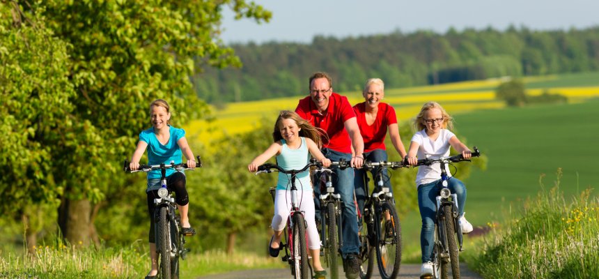 Family with kids cycling in summer with bicycles Famillie fährt Fahrrad