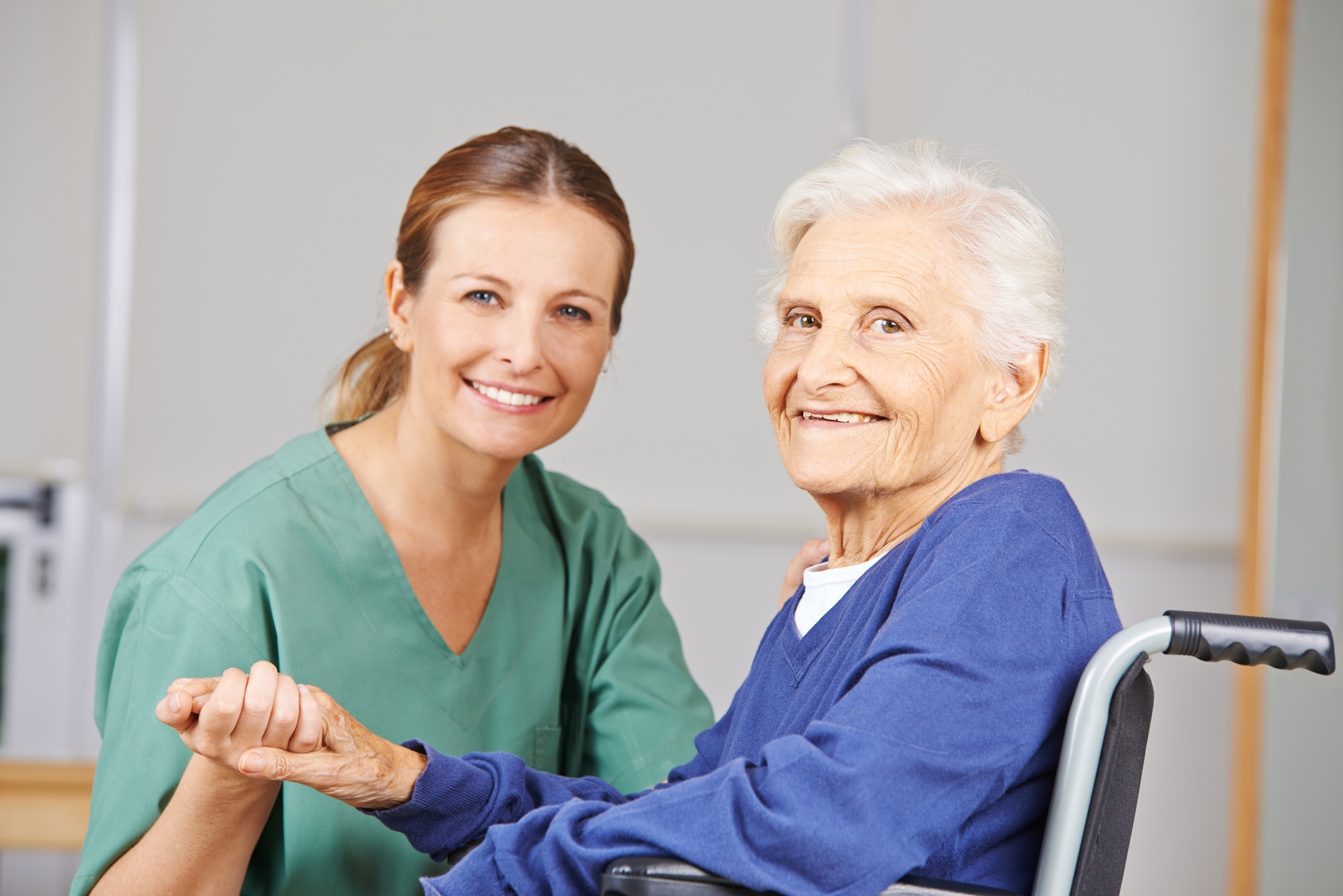 Altenpflege durch lächelnde Krankenschwester bei einer glücklichen Seniorin