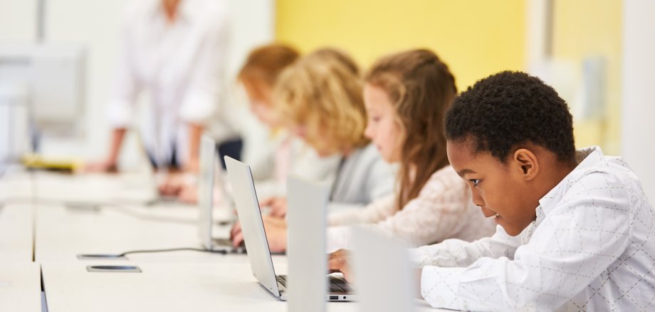 Gruppe Schüler im Computer Kurs einer Grundschule lernt online am Laptop