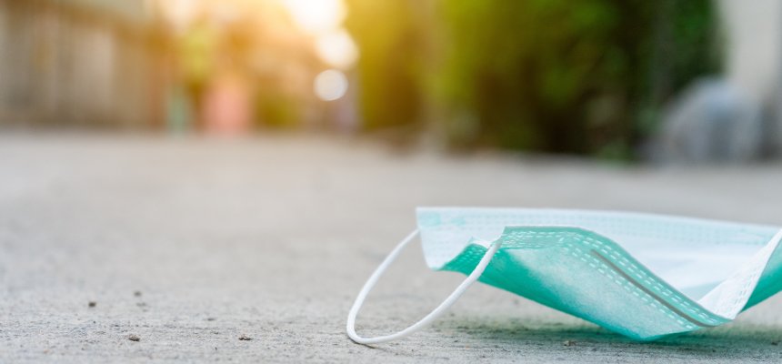 Medizinischer Mundschutz liegt auf einer Straße. 