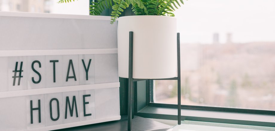 Lichtbox mit Buchstaben, die #stayhome zeigen und auf einer Fensterband steht