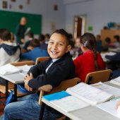 Glücklicher Schüler in voll besetzem Klassenraum