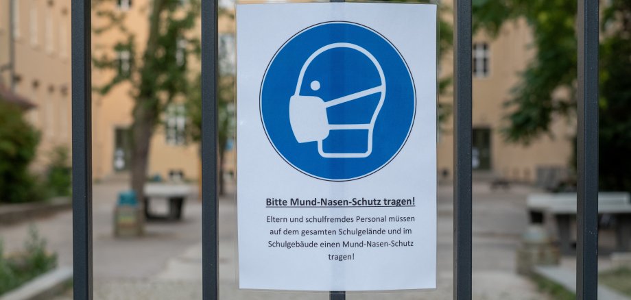 Hinweisschild zur Maskenpflicht am Eingang einer Schule