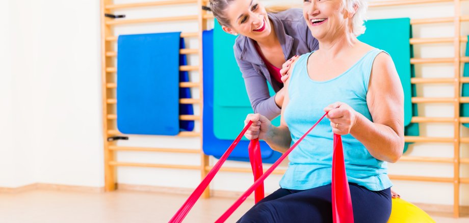 Senior woman with stretch band at fitness