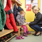 Mutter holt Kind von Kindergarten ab