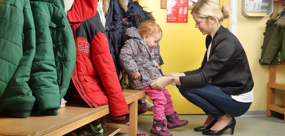 Mutter holt Kind von Kindergarten ab