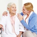 Lachende Seniorin zu Hause schaut ihre Tochter an