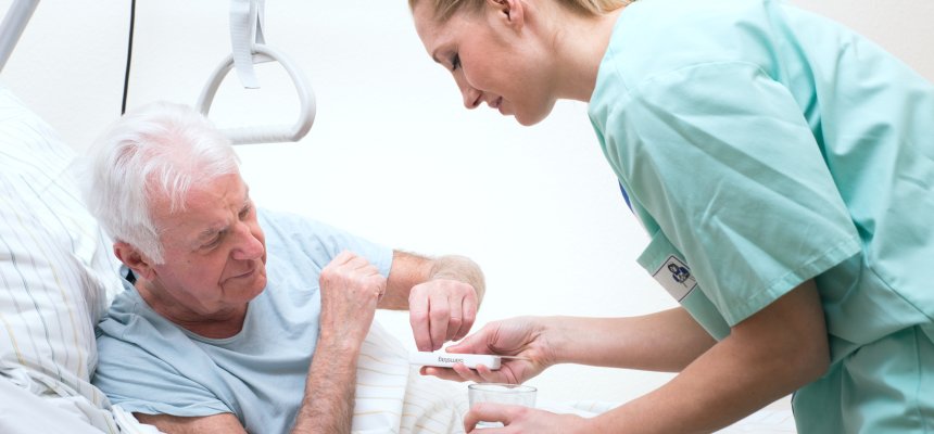 Senior mit Pflegerin im Altenheim Medikamenteneinnahme