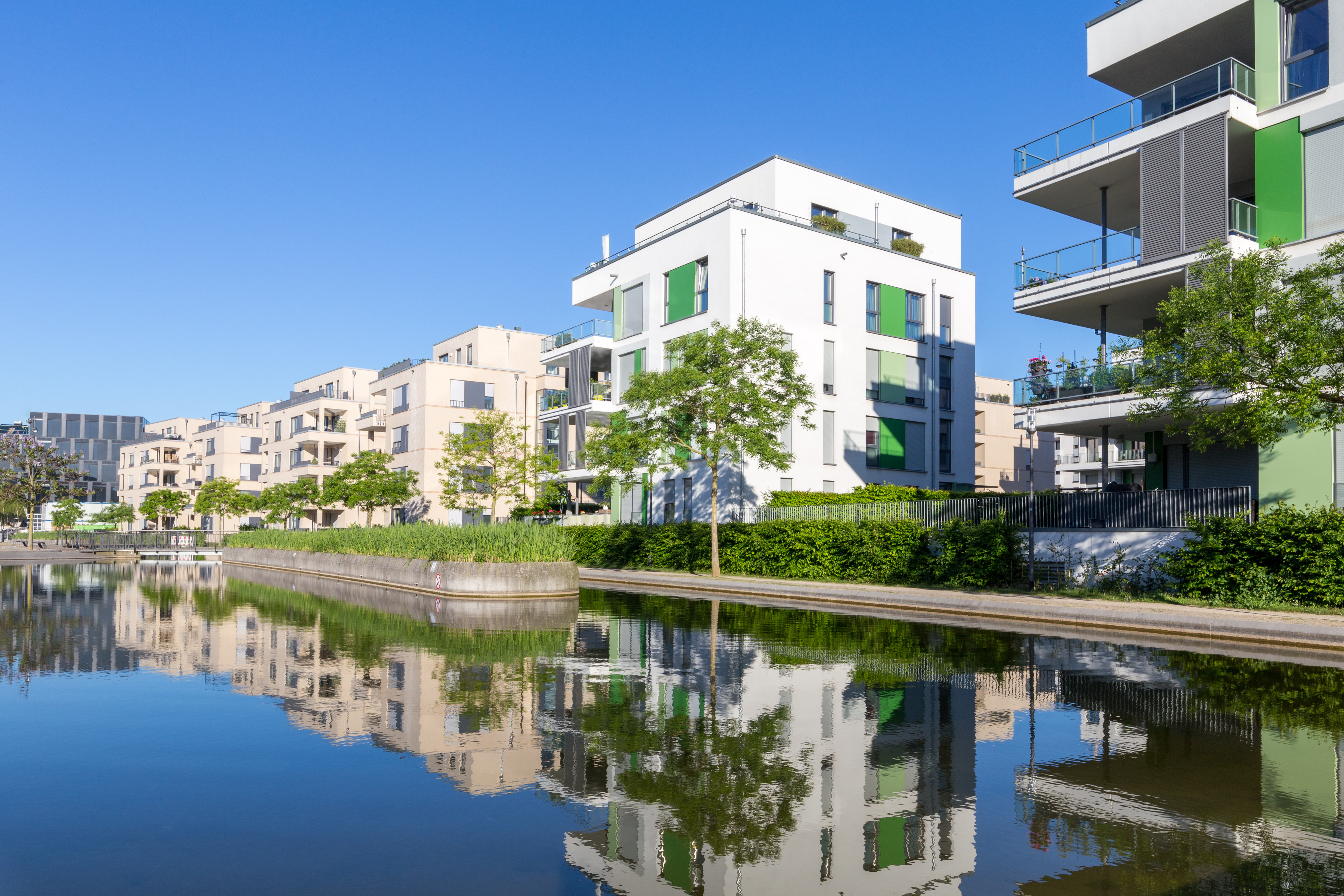 Modernes Wohngebiet in einer Parkanlage mit Wasser