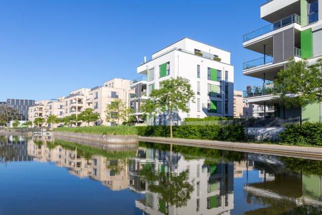 Modernes Wohngebiet in einer Parkanlage mit Wasser