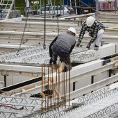 Zwei Bauarbeiter setzen Modul auf Bastelle ein