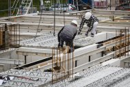 Zwei Bauarbeiter setzen Modul auf Bastelle ein