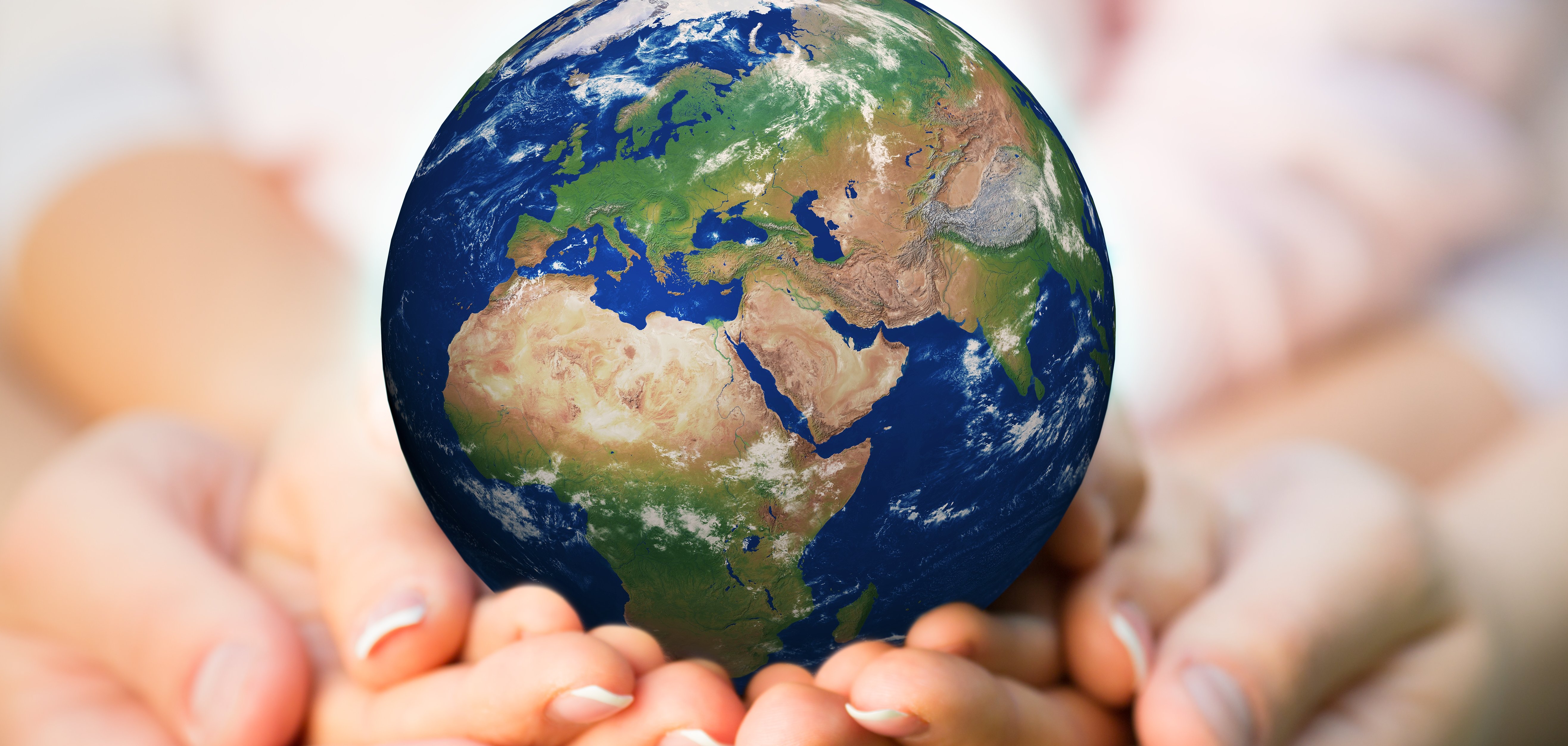 Familie hält den Erdball in den Händen. 