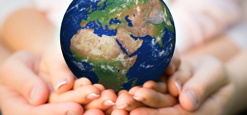 Familie hält den Erdball in den Händen. 