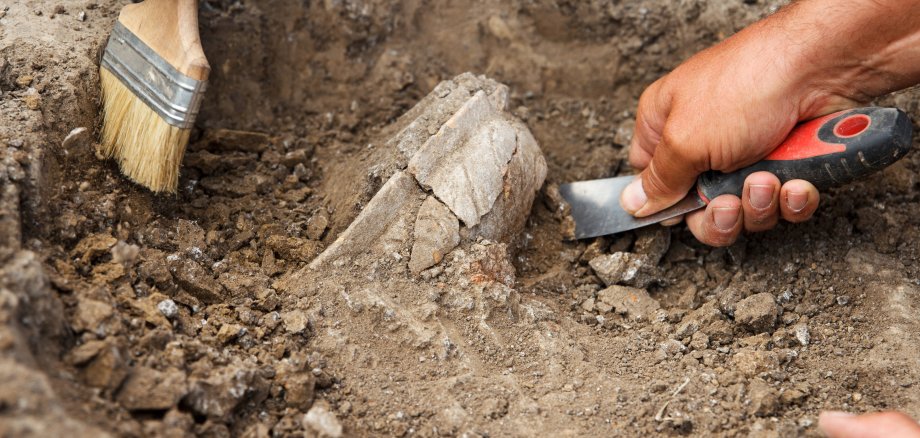 Archaeological excavations, archaeologists work, dig up an ancient clay artifact with special tools