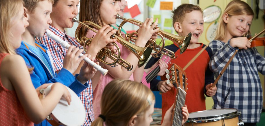 Gruppe von Schülerinnen und Schülern bei einer Probe in einer Musikschule oder Schulorchester.
