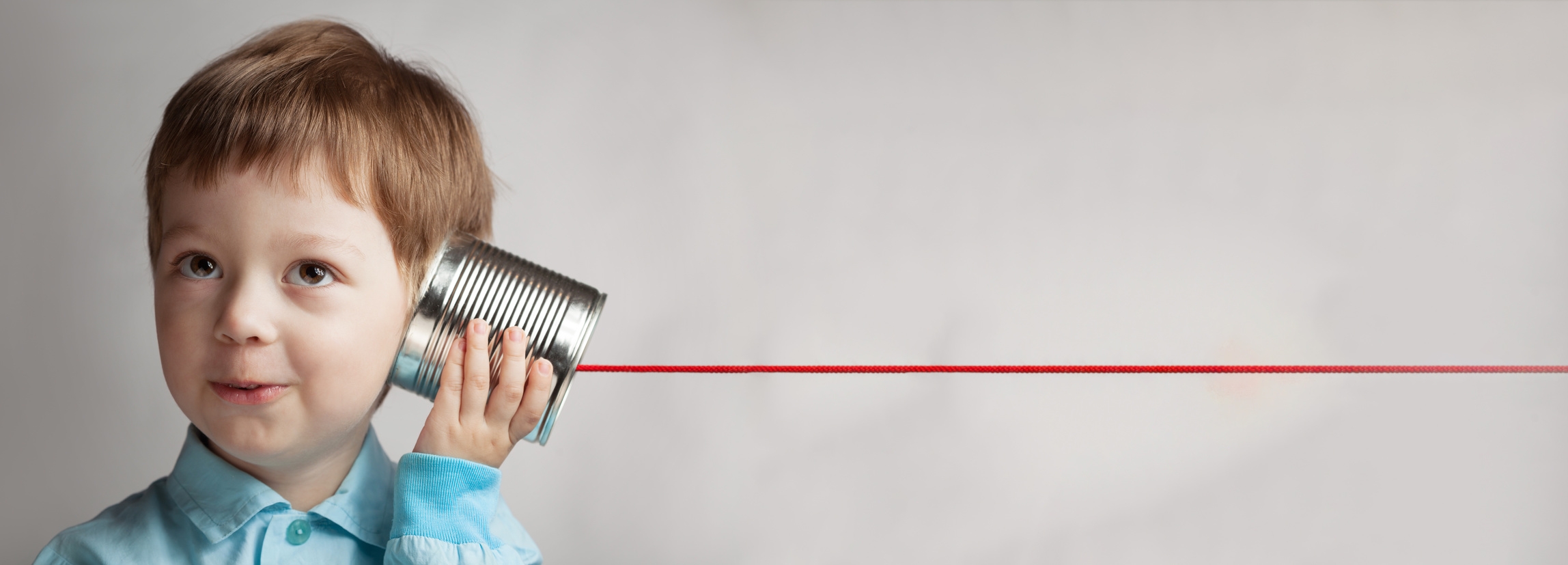 Junge spielt mit Dosentelefon