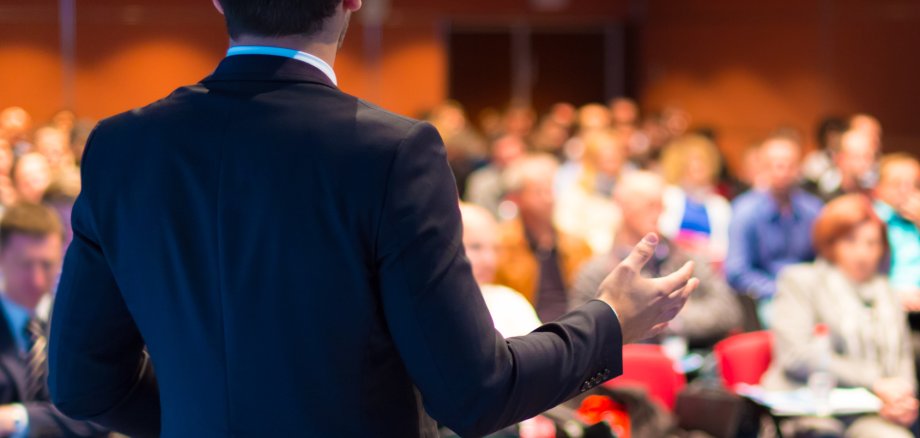 Redner auf einer Konferenz und Publikum im Saal