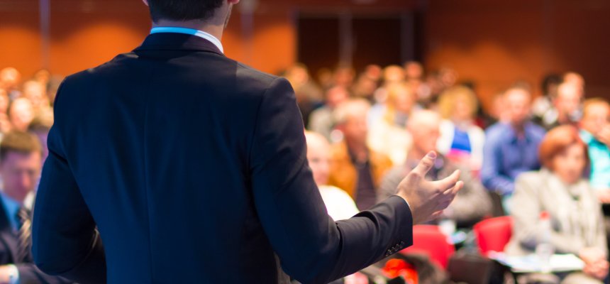 Redner auf einer Konferenz und Publikum im Saal