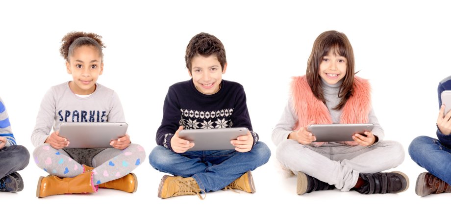 Kinder spielen mit Tablets