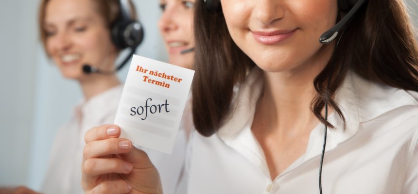 Arzthelferin am Telefon mit Zettel "nächster Termin sofort"